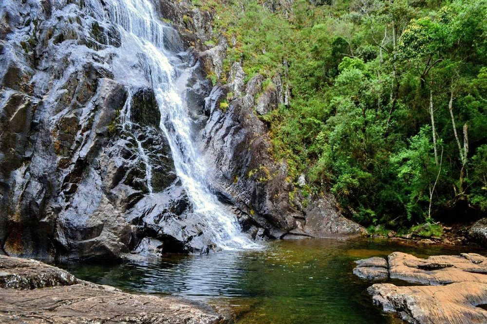 A Cachoeira Bonita despencando por um paredão de rocha cercado de mata