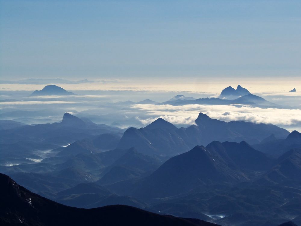 Cristas da serra emergindo do mar de nuvens, vistas do alto do Pico da Bandeira