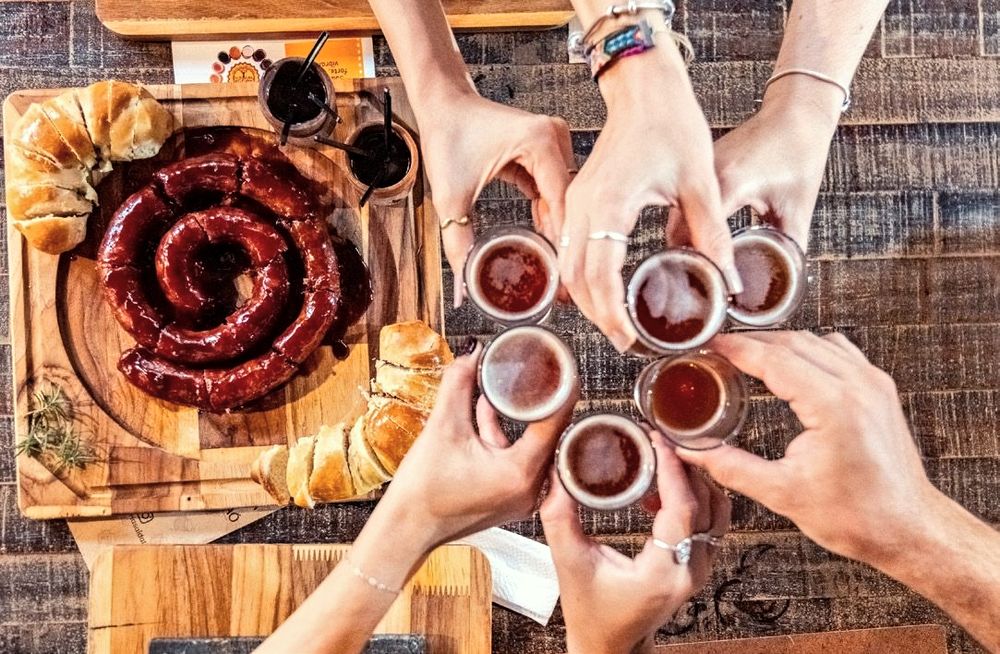 Brinde com copos de cerveja artesanal sobre a mesa de madeira