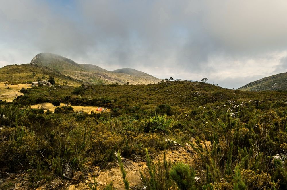 O campo de altitude em volta do acampamento do Terreirão, com nuvens baixas sobre as montanhas